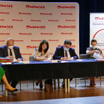 Zdjęcie przedstawia 5 siedzących przy stole osób. Wśród nich znajduje się Burmistrz Mariusz Kucewicz wraz ze Skarbniczką Martą Stasiuk oraz Ewa Janina Orzełowska (członek Zarządu Województwa Mazowieckiego). Są w trakcie podpisywania umów.